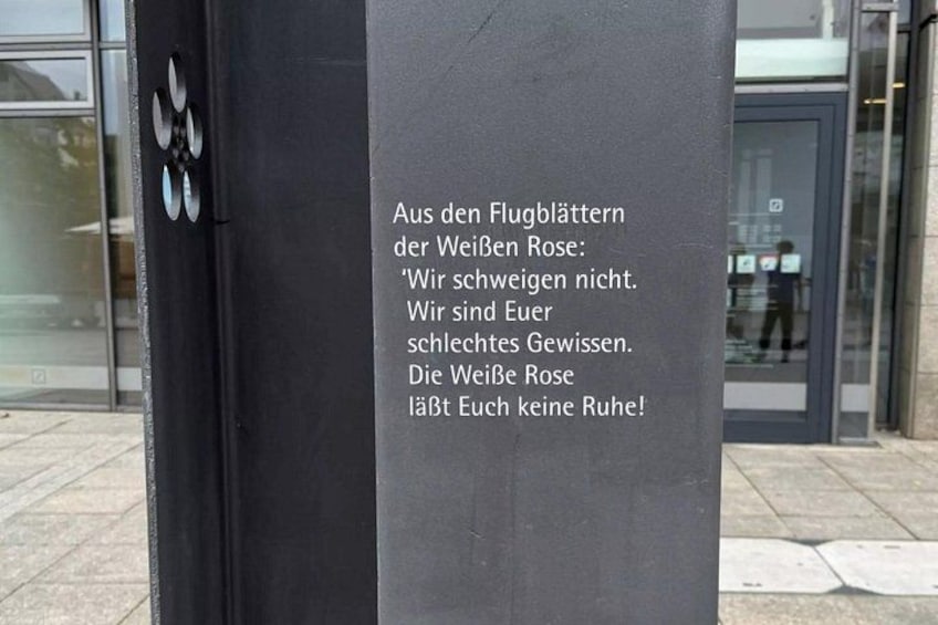 A black metal structure with a plaque containing text in German. 5