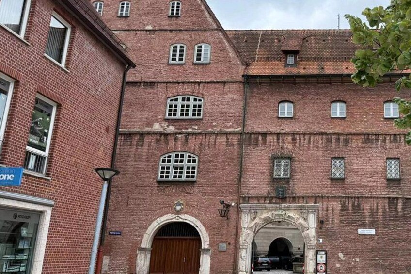 A red brick building with multiple windows and a large wooden door. 4