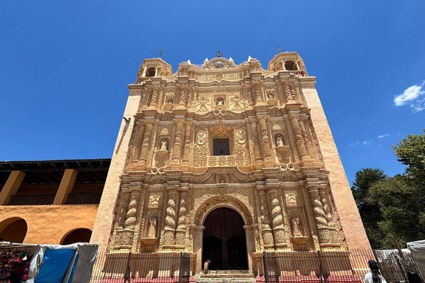 Un edificio grande y ornamentado con tallas elaboradas y un arco imponente. 5