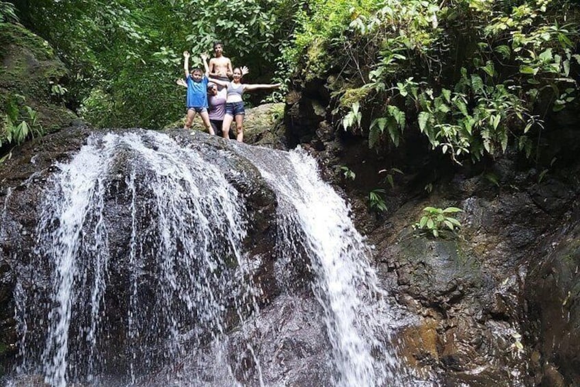 A waterfall with people standing on a rock. 5