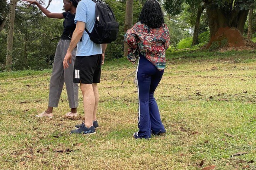 People standing on a grassy field with trees in the background. 2