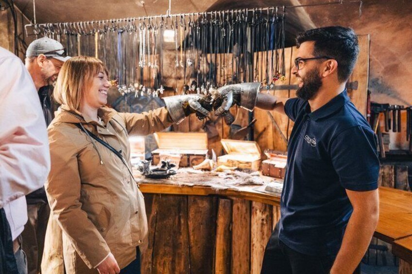 A workshop with tools hanging on the wall and a person working on a wooden piece. 2