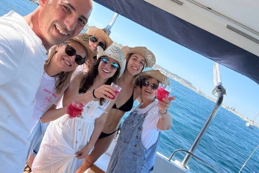 A group of people on a boat with a clear view of the sea and a distant shoreline. 3