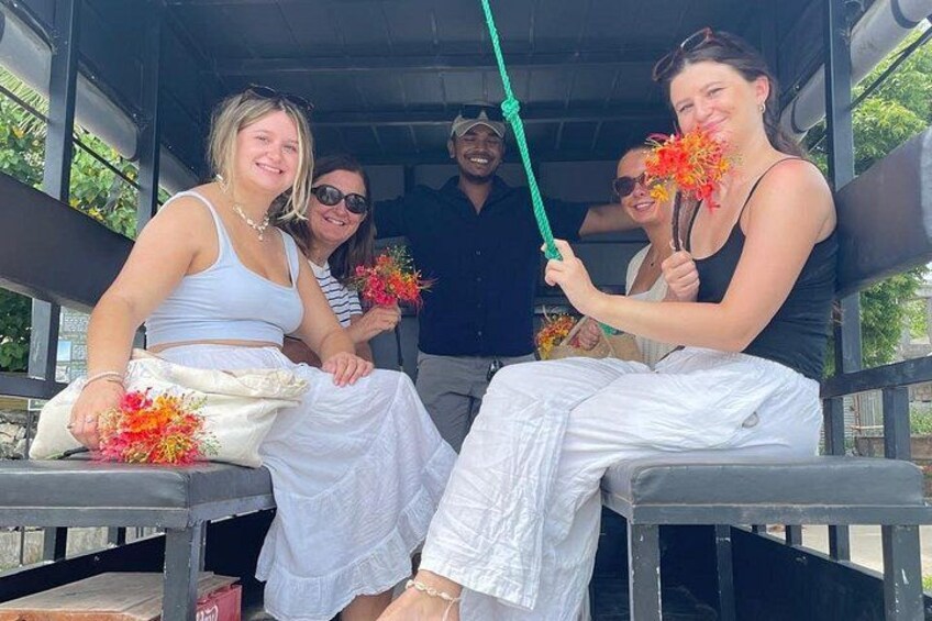 Four people sitting on a bench, holding flowers. 3