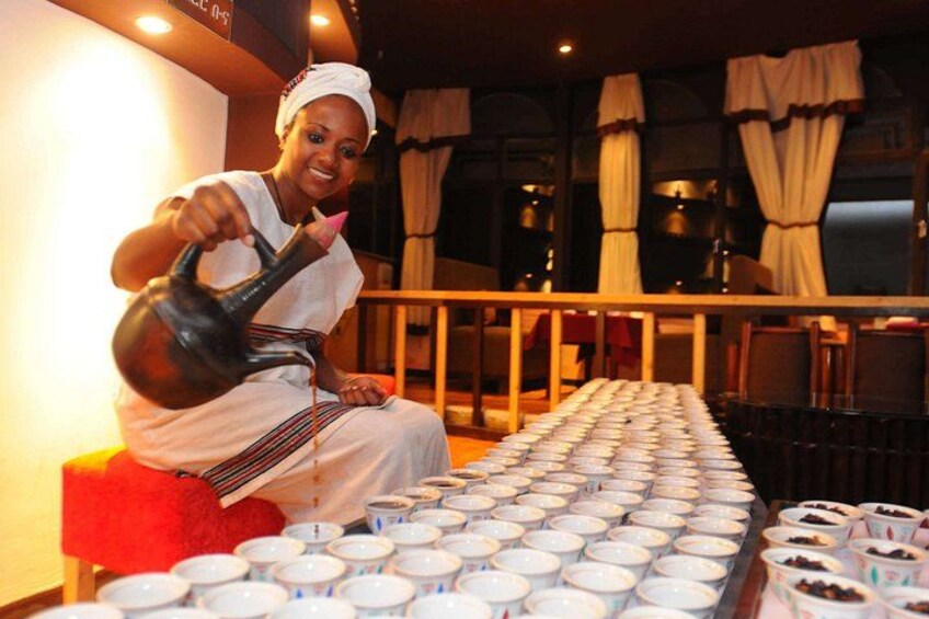 A person pouring tea from a teapot into a cup. 4