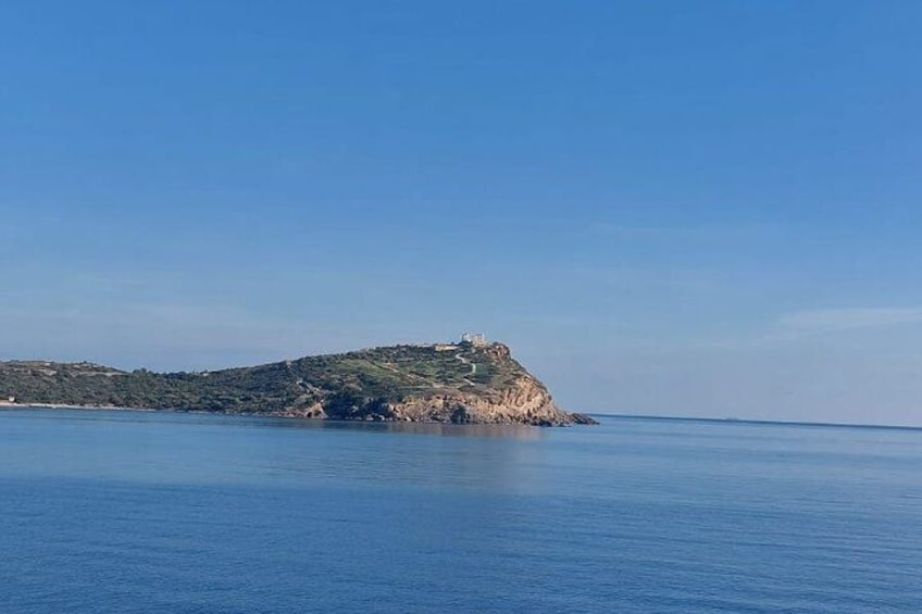 A coastal landscape with a small island featuring a building on top. 4
