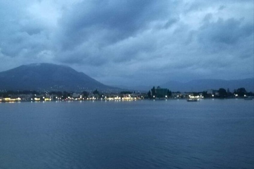 A coastal cityscape at dusk with a mountain in the background. 2