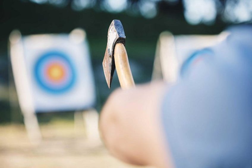 An arrow nocked to a bow, a target in the background, and a blurred person in the foreground. 1