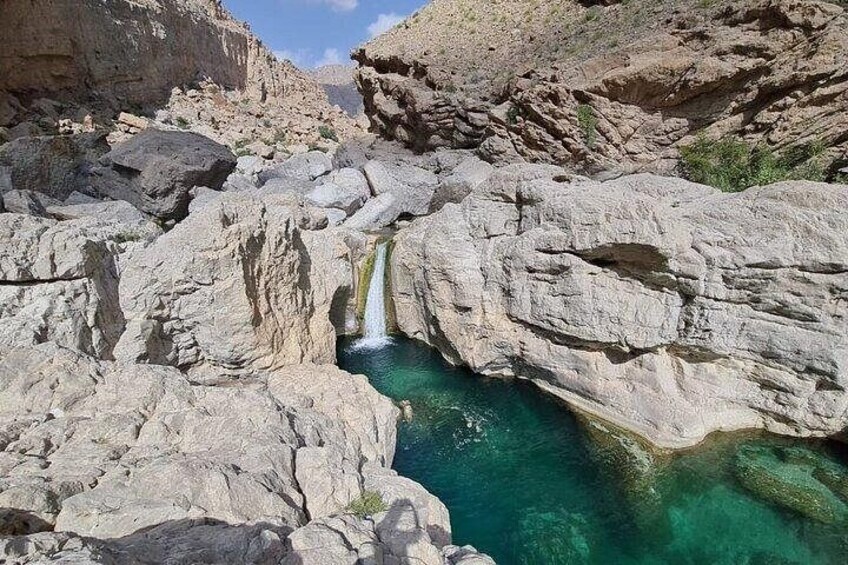 Ein felsiger Canyon mit einem Wasserfall und klarem, türkisblauem Wasser. 5