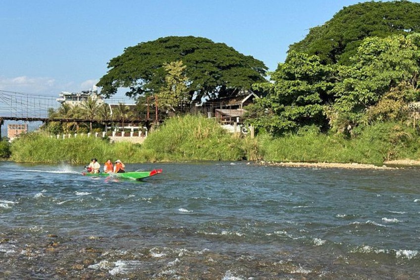 A river with kayaks, a bridge, and lush greenery. 4