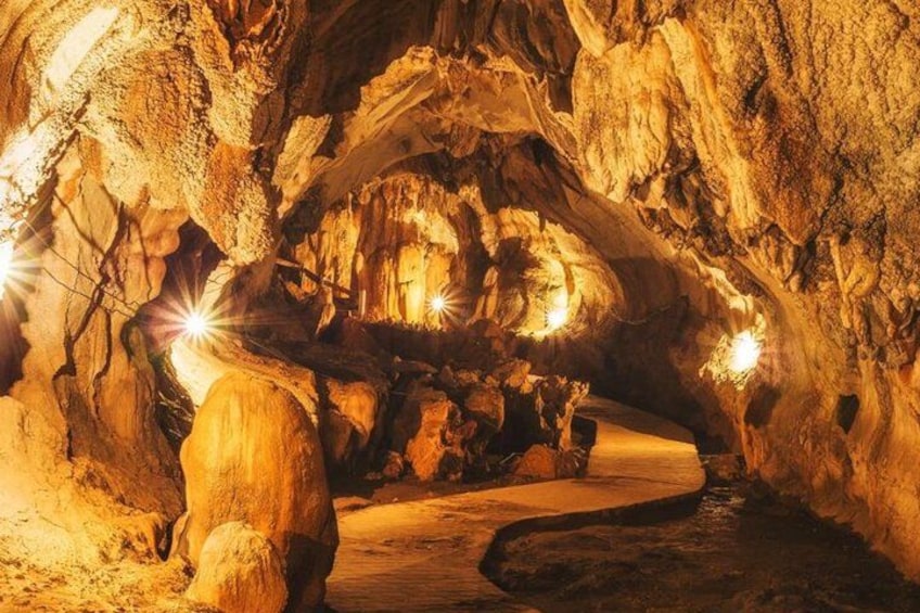 A cave with stalactites and stalagmites, illuminated by artificial lights. 5