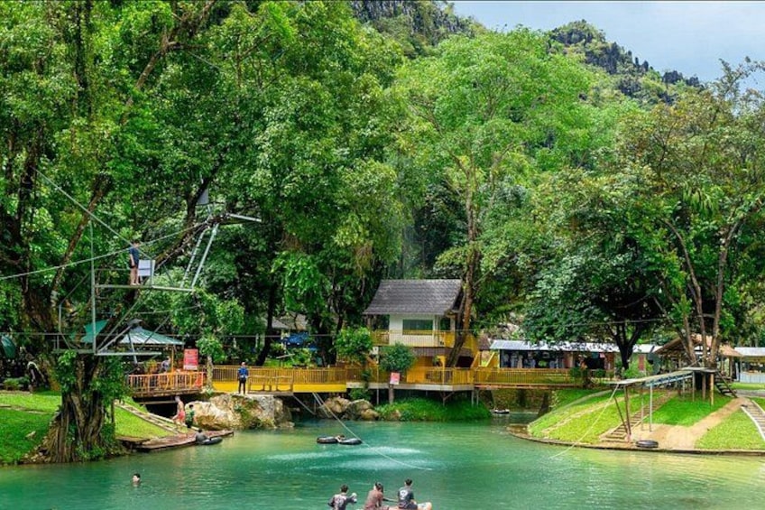 A river with a bridge, a boat, and a building surrounded by trees. 1