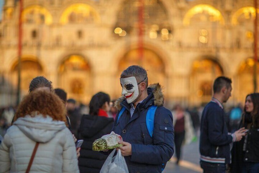 A person in a dark jacket with a fur-lined hood holding a plastic bag. 2