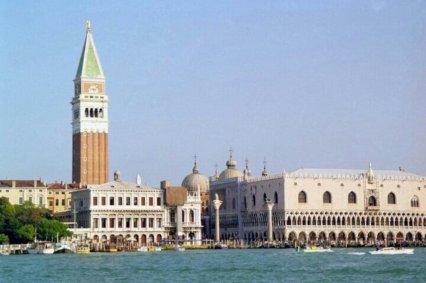 A historic building with a prominent tower and domes, located by a waterfront. 4