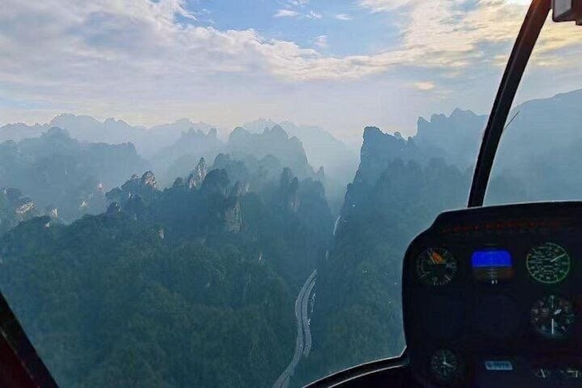 A helicopter cockpit with a view of a mountainous landscape. 4