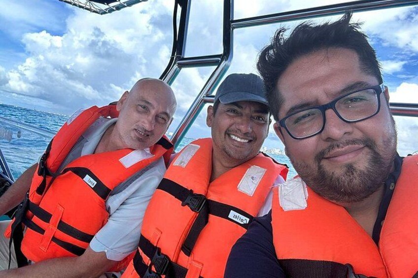 Three people wearing life jackets on a boat. 2