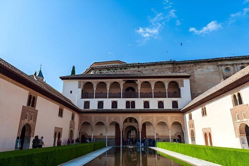 A courtyard with a central pool, arches, and a building with multiple levels. 4