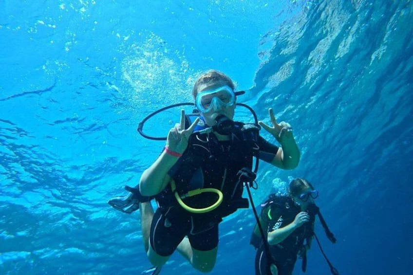 A diver underwater with a snorkel and fins, surrounded by clear blue water. 3