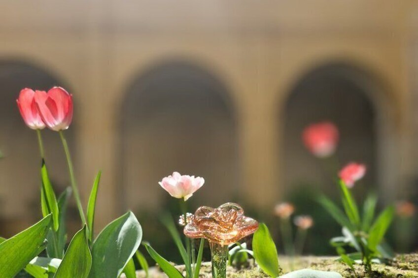 A garden with pink tulips and a glass sculpture. 2