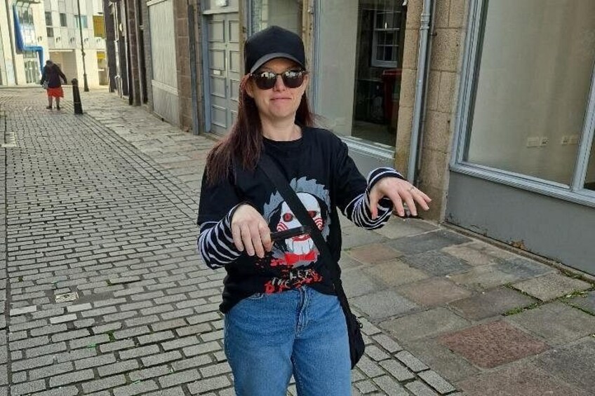A person standing on a cobblestone street with buildings in the background. 3