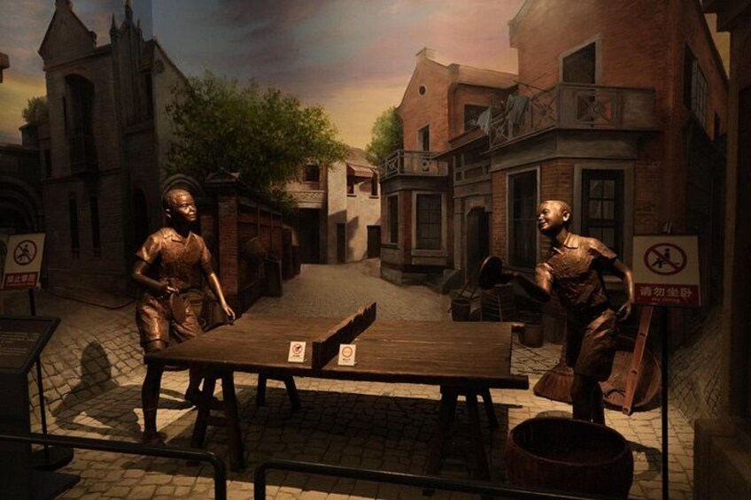 A street scene with buildings, a table, and two figures. 4