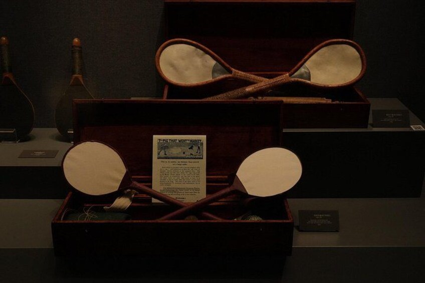 A display case containing a pair of antique eyeglasses, a magnifying glass, and a small booklet. 5