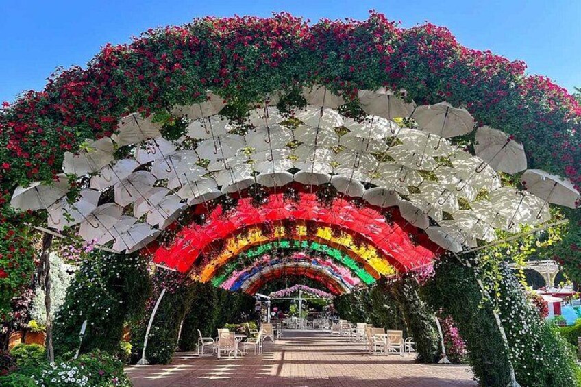A colorful archway with white umbrellas and a rainbow pattern. 3