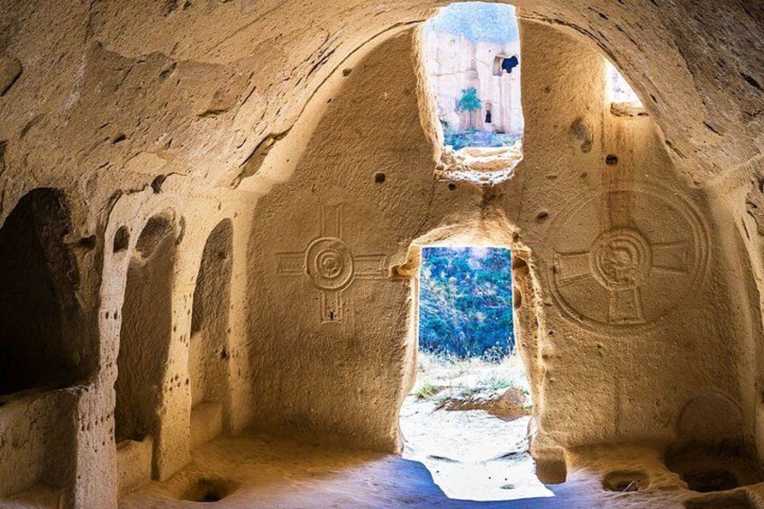 An interior of a cave with natural rock formations, a central opening, and a window. 5