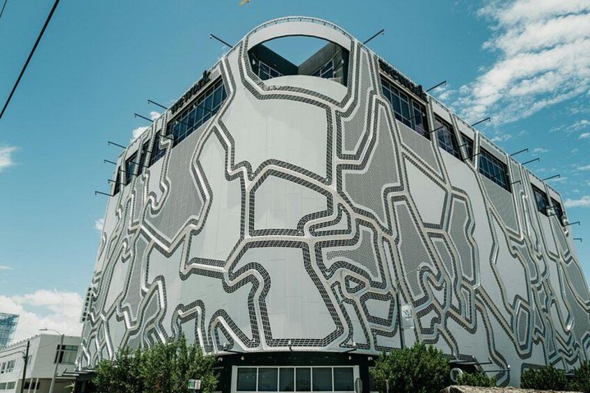 A modern building with a unique geometric facade and a large arched window. 2