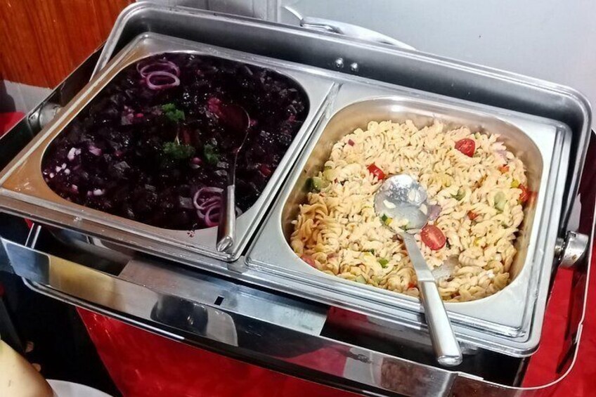 A buffet with two dishes: one appears to be a red beet salad and the other a pasta dish with vegetables. 2