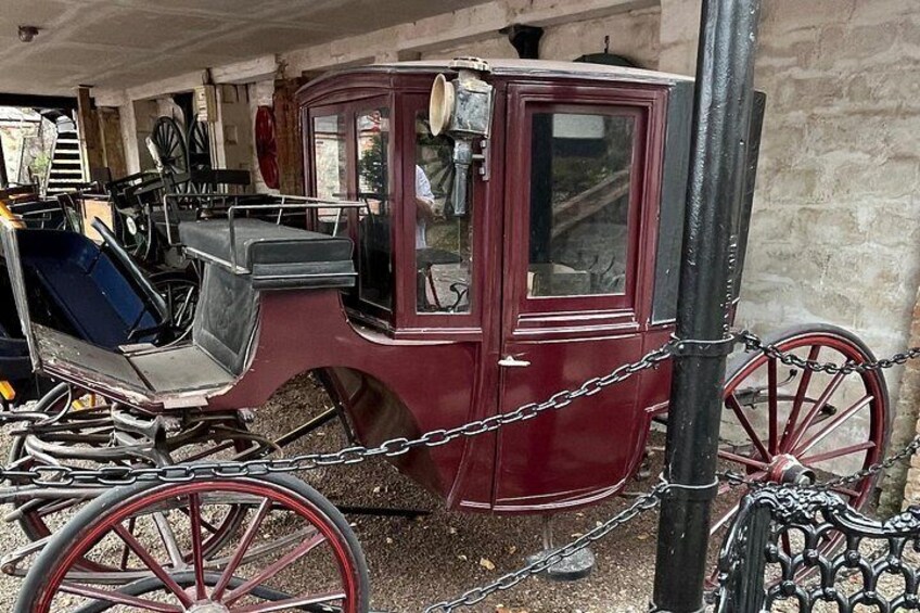 A vintage red carriage with black harnesses and a chain. 4
