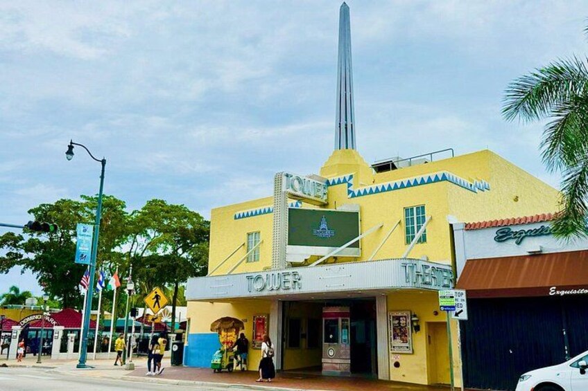 Un bâtiment jaune avec une enseigne indiquant « TOWER THEATER » et une haute flèche. 3