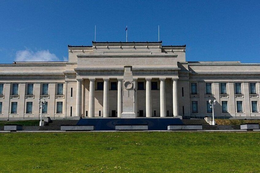 A large, symmetrical building with columns and a central entrance, surrounded by a well-maintained lawn. 3