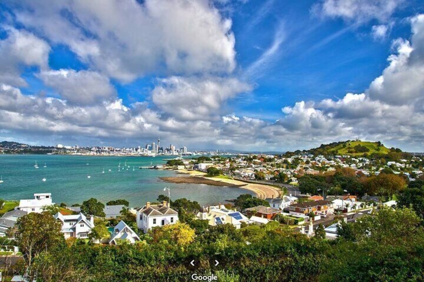 A coastal town with houses, a beach, and a distant city skyline. 2