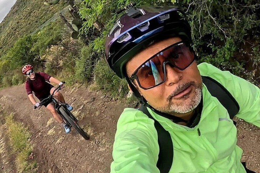 A person on a mountain bike on a dirt trail with greenery in the background. 4
