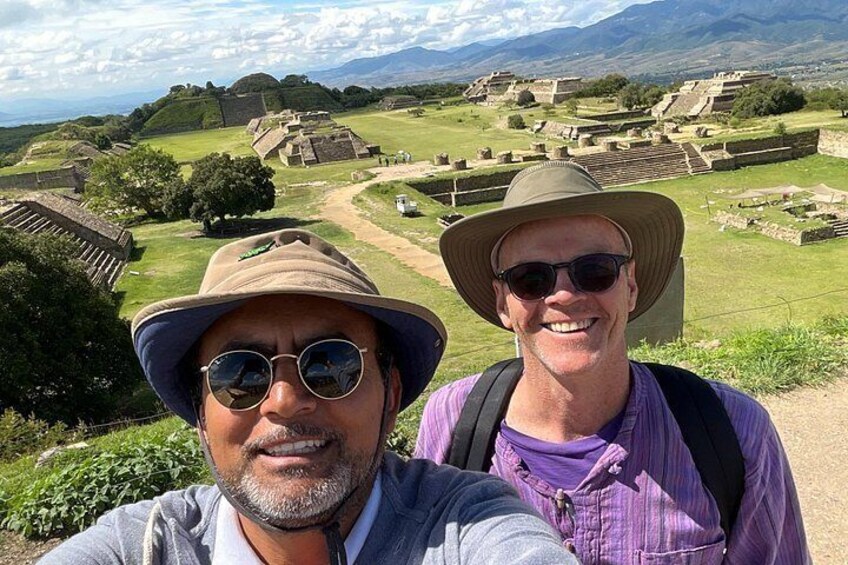 Two people taking a selfie with ancient ruins in the background. 1