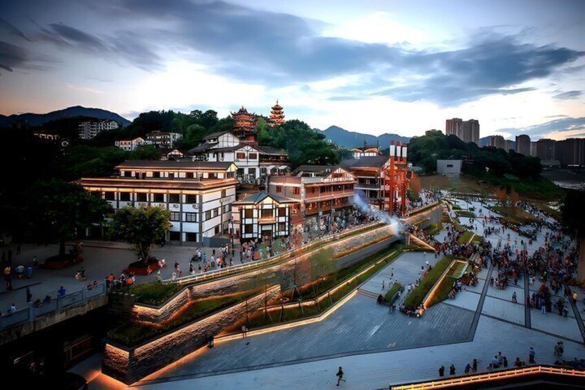 A traditional building with a pagoda-style roof, surrounded by a plaza with people and a fountain. 2