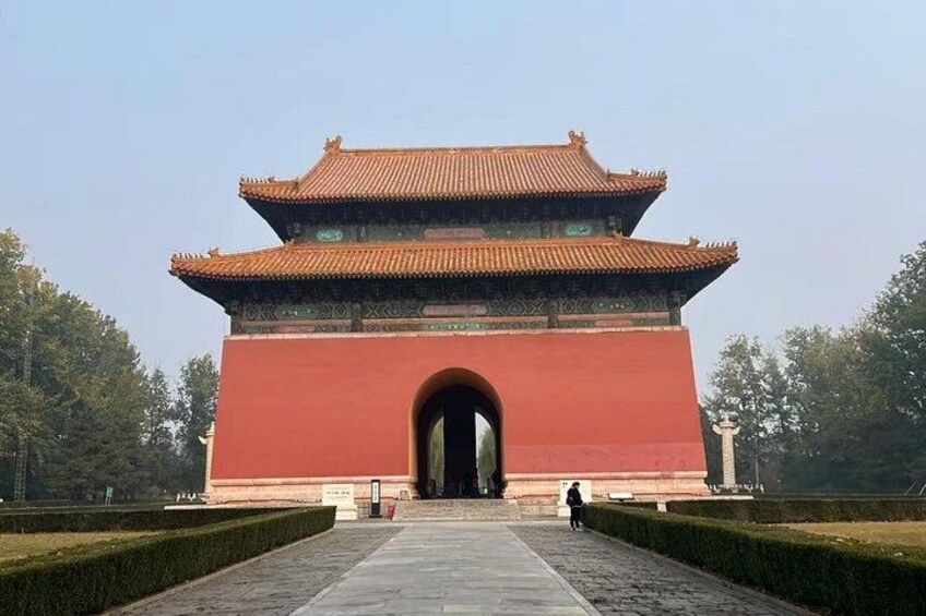 A traditional Chinese gate with a red facade and a tiled roof. 2