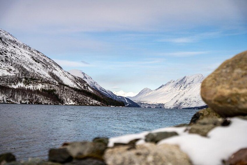 A lake surrounded by snow-covered mountains, with a clear sky. 4