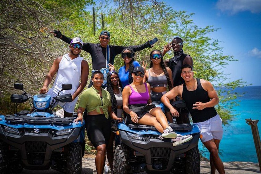 A group of people on ATVs near a body of water. 2