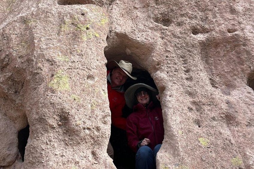 Two people sitting inside a rock formation. 2