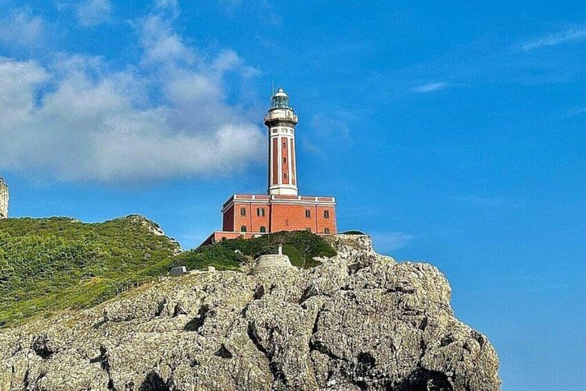 A lighthouse on a rocky hill with a clear blue sky. 4