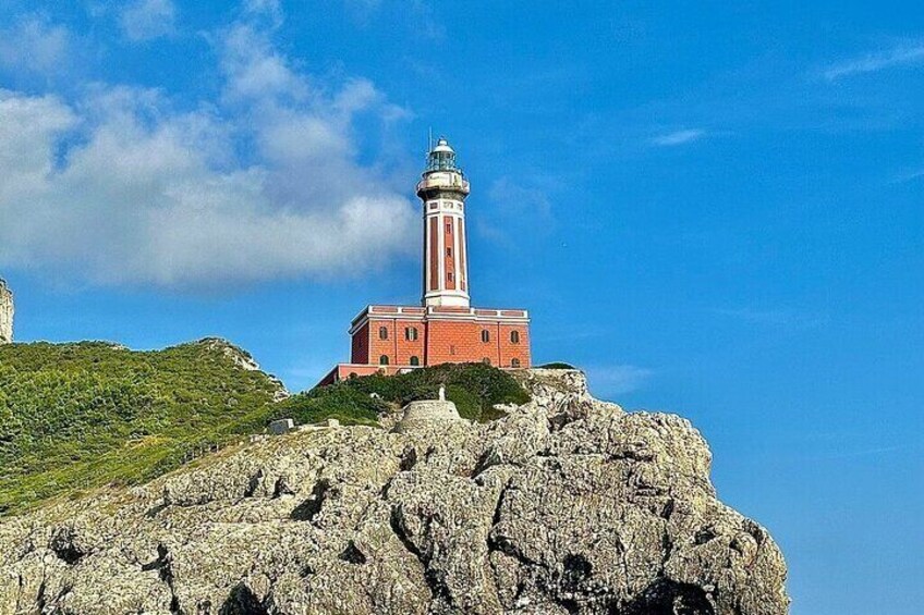 A lighthouse on a rocky hill with a clear blue sky. 4