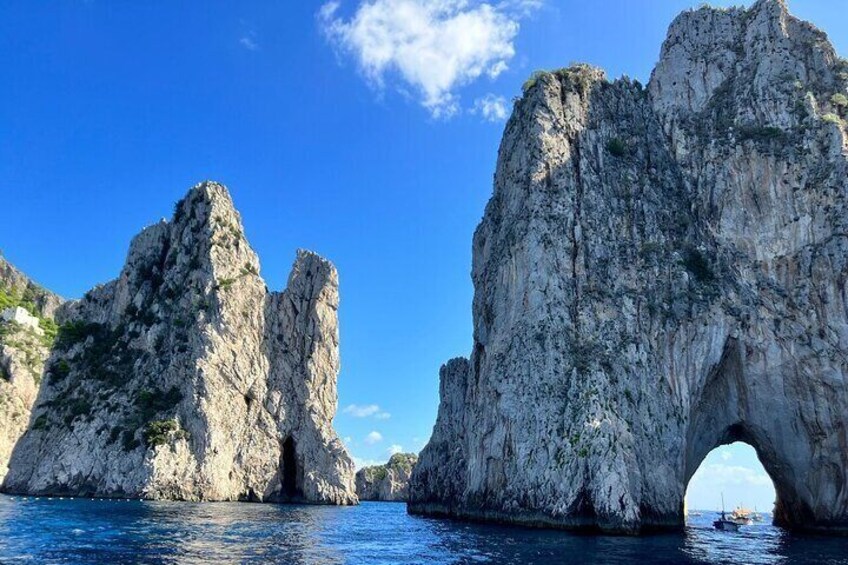 A rocky coastal landscape with prominent limestone formations and a clear blue sky. 1