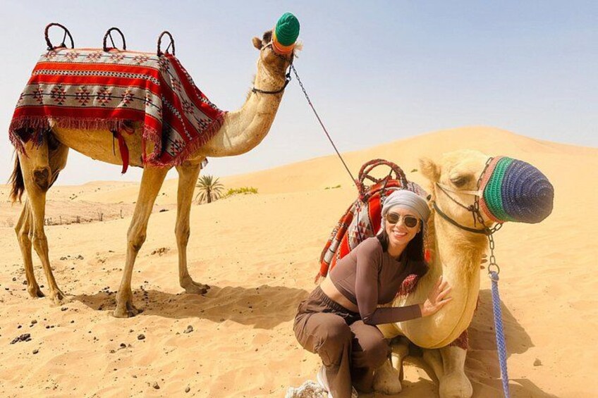 A camel with a saddle and a person sitting on it in a desert. 3