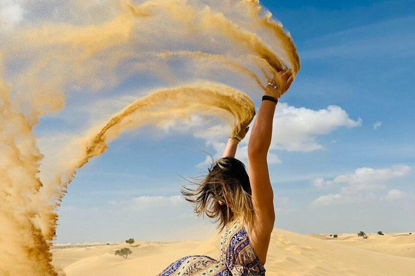 A person in a patterned dress with a desert landscape in the background. 4