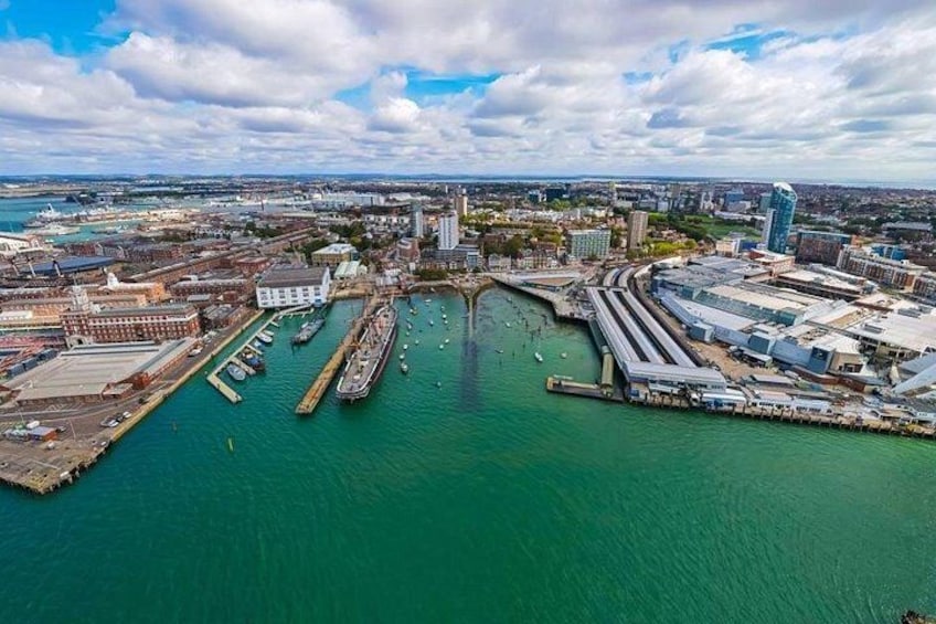 Ein Hafen mit mehreren Anlegestellen, einem großen Schiff und Industriegebäuden. 3