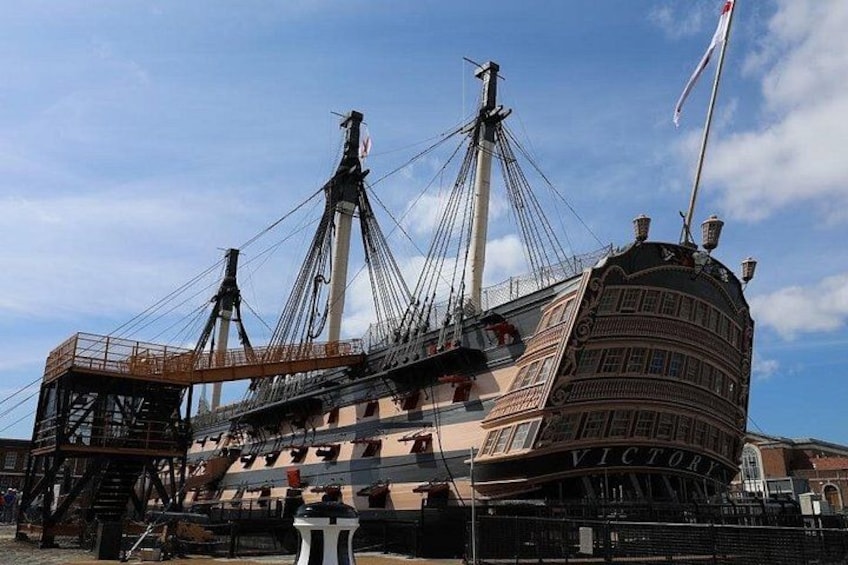 Ein großes Schiff mit mehreren Masten und einem gewölbten Bug liegt im Hafen festgemacht. 2