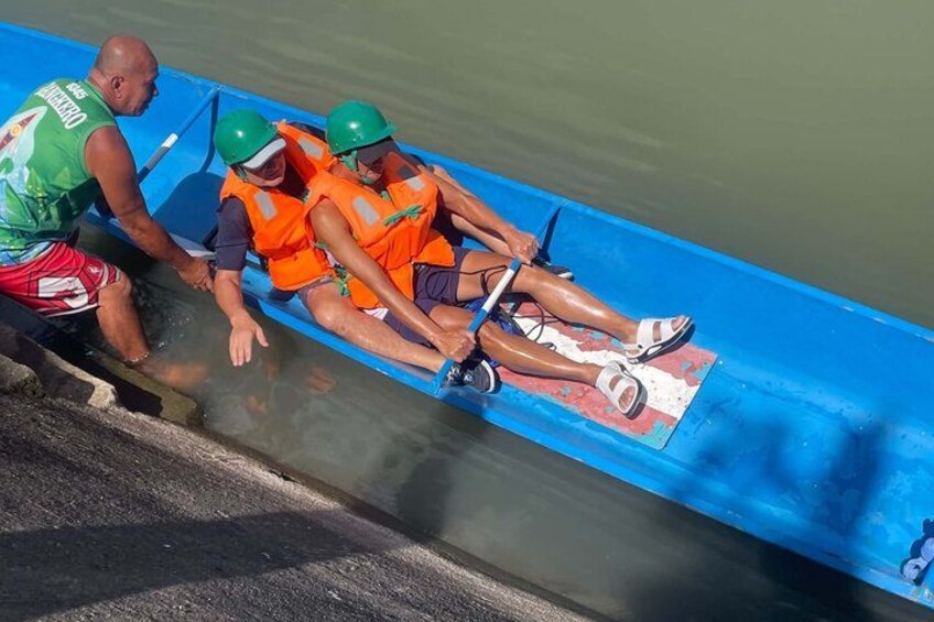 A blue boat with three people wearing life jackets and helmets. 5