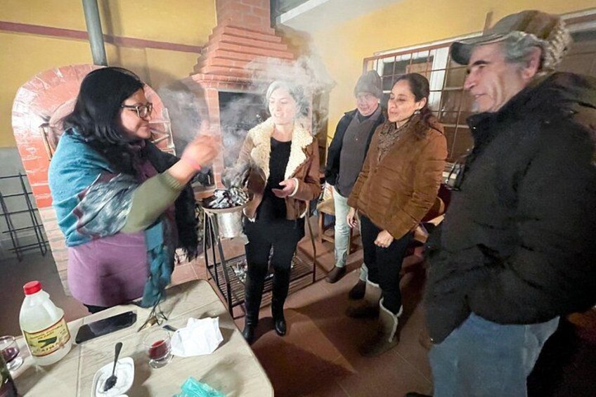 Un gruppo di persone intorno a un forno a legna, con del fumo che si alza, a indicare attività di cottura o panificazione. 4